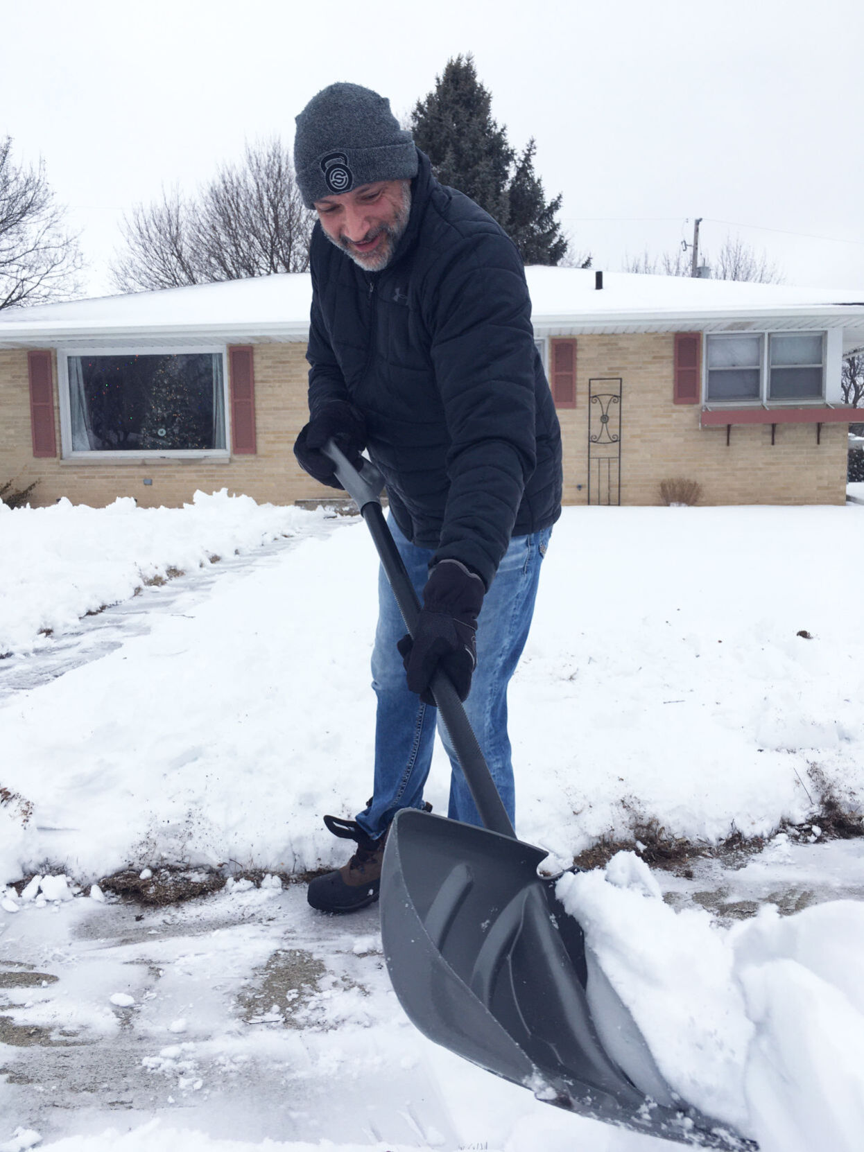 Kurt Lakatos of Burlington shovels snow outside his home